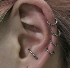 a close up of a person's ear with three different piercings on it