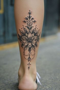 a woman's leg with a flower tattoo on the top and bottom of it