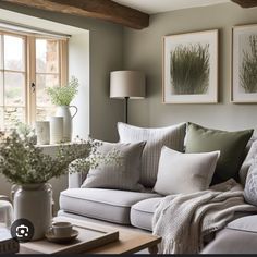 a living room filled with lots of furniture next to a window covered in pillows and blankets