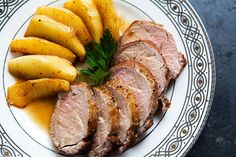 sliced meat and potatoes on a white plate