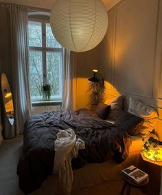 a bedroom with a bed, lamp and window