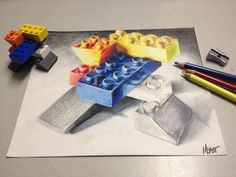 colored pencils and crayon pencils next to a drawing of lego blocks