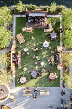 an overhead view of people sitting at tables in the grass