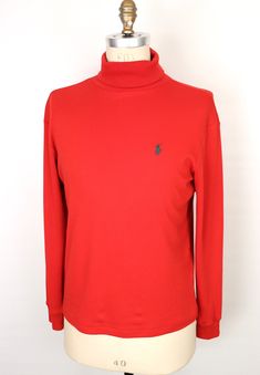 "\"The Rockefeller Center\" vintage 1990s turtleneck by iconic American designer label Polo Ralph Lauren in rich red 100% soft cotton with classic embroidered chest logo of polo player in green--Beautiful condition!  SIZE: Tagged Men's Small MEASUREMENTS (unstretched Chest (underarm to underarm): 21\" Waist: 20\" Length (base of back collar to hem): 25.5\" Turtleneck Collar (folded): 2.5\" Shoulder: 19.5\" Sleeve: 23.5\" *All measurements taken seam-to-seam lying flat and should be doubled where Ralph Lauren Turtleneck, Green Polo, Rockefeller Center, Designer Label, Green Logo, American Design, Pullover Sweaters, Sweater Outfits, Polo Ralph