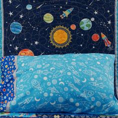 a blue pillow with an image of the solar system on it and some space themed pillows