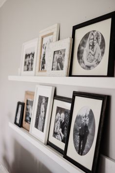 some pictures are hanging on a white shelf