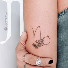 a woman's arm with a flower tattoo on the left side of her arm