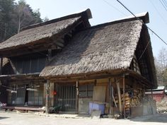 an old wooden building with a thatched roof