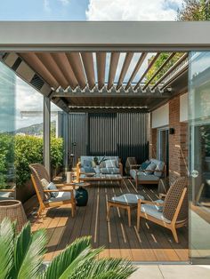 an outdoor living area with wooden furniture and large glass doors on the side of it