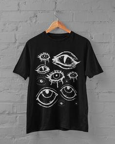 Thanks for stopping by! Eyes T-shirt Printed on a super soft, cotton tee Dispatched in 5 working days or sooner Unisex Free UK delivery ECO-FRIENDLY Each garment is made to order, reducing extra material and energy that would be otherwise wasted We use DTG printing process which is easier on the environment than screen-printing Our ink is bright and also eco-friendly. Material: 100% ringspun cotton. Chest (to fit): S  34/36   M  38   L  40/42   XL  44/46   XXL  48/50 Do not tumble dry Wash at 30 Custom Tee Shirts Design, Goth T Shirt Designs, Grunge Tshirt Diy, Screen Printed T Shirts, Punk T Shirt Design, Alt Shirt Designs, Goth Tshirt Design, Bleached Tshirt Designs, Goth Shirt Design