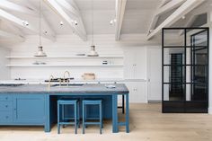 a kitchen with an island and blue stools