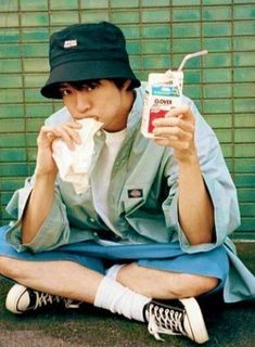 a man sitting on the ground eating something