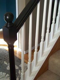 a black and white banister next to a blue wall