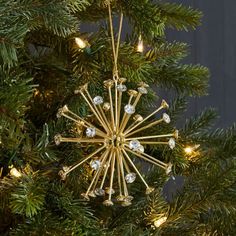 a gold christmas ornament hanging from a tree