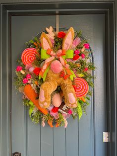 a wreath on the front door decorated with candy and stuffed animals