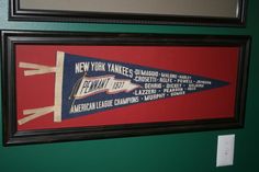 two framed pictures hang on the wall next to each other, one with an american league pennant