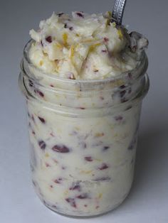 a jar filled with ice cream sitting on top of a white table next to a spoon