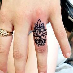 a woman's hand with a tattoo on it and a ring in the middle