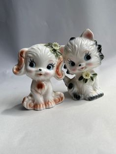 two porcelain figurines sitting next to each other