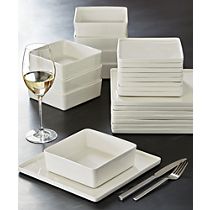 a table topped with white dishes and wine glasses