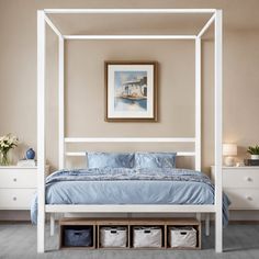 a white canopy bed with blue sheets and pillows