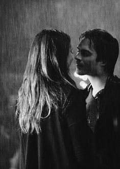 black and white photograph of two people kissing in the rain