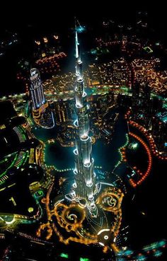 an aerial view of the burj at night, with lights in the buildings