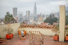 an outdoor patio area with potted plants and buildings in the background