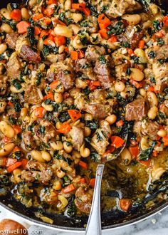 a skillet filled with meat, beans and vegetables