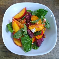 a white bowl filled with salad and fruit