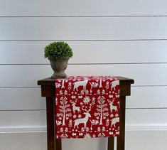 a potted plant sitting on top of a wooden table next to a red and white cover