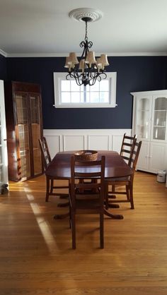 an empty dining room with blue walls and wood flooring is seen in this image