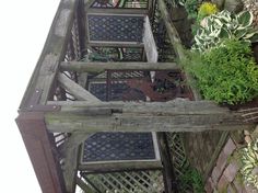 a wooden gazebo sitting in the middle of a garden