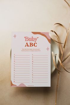 a baby abc game sitting on top of a table next to some dried grass and a cup