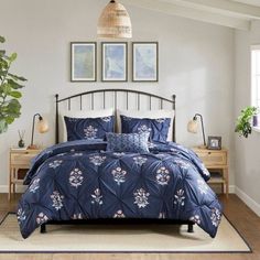 a bed in a bedroom with blue comforter and pillows