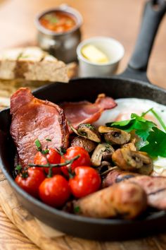 a pan filled with bacon, mushrooms and tomatoes