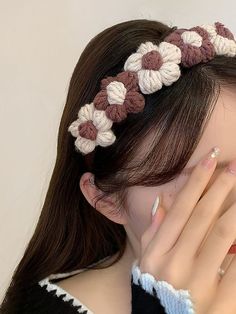 a woman with her hands on her face wearing a crochet flower headband