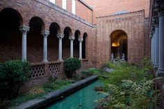 an outdoor courtyard with green water and columns