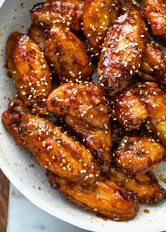 sesame seed chicken wings in a white bowl