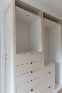 an empty closet with blue tape on the drawers and white paint all over the walls