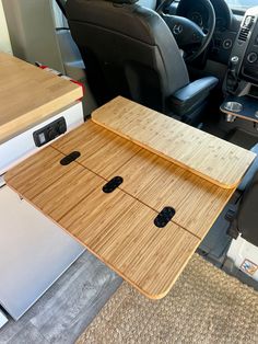 a wooden board sitting on top of a table in the back of a truck with two doors open