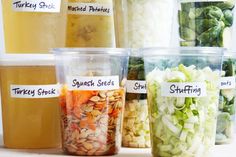 there are many different types of food in plastic cups on the table, all labeled with labels