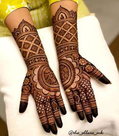 two hands with henna tattoos on them