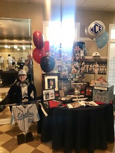 a baseball themed party with balloons and pictures on the wall, including an autograph table