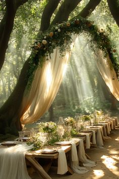 an outdoor wedding setup with white linens and greenery draped over the head table