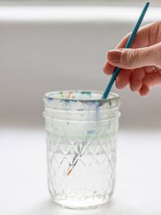 a person is holding a pencil in a jar