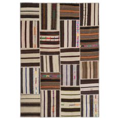 a patchwork rug with multicolored squares and stripes on the front, in various colors