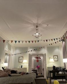 a living room filled with furniture and a chandelier hanging from the ceiling above it