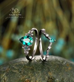 two wedding rings with green and white stones