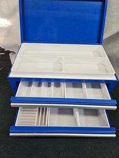 three blue and white trays are stacked on top of each other in a box